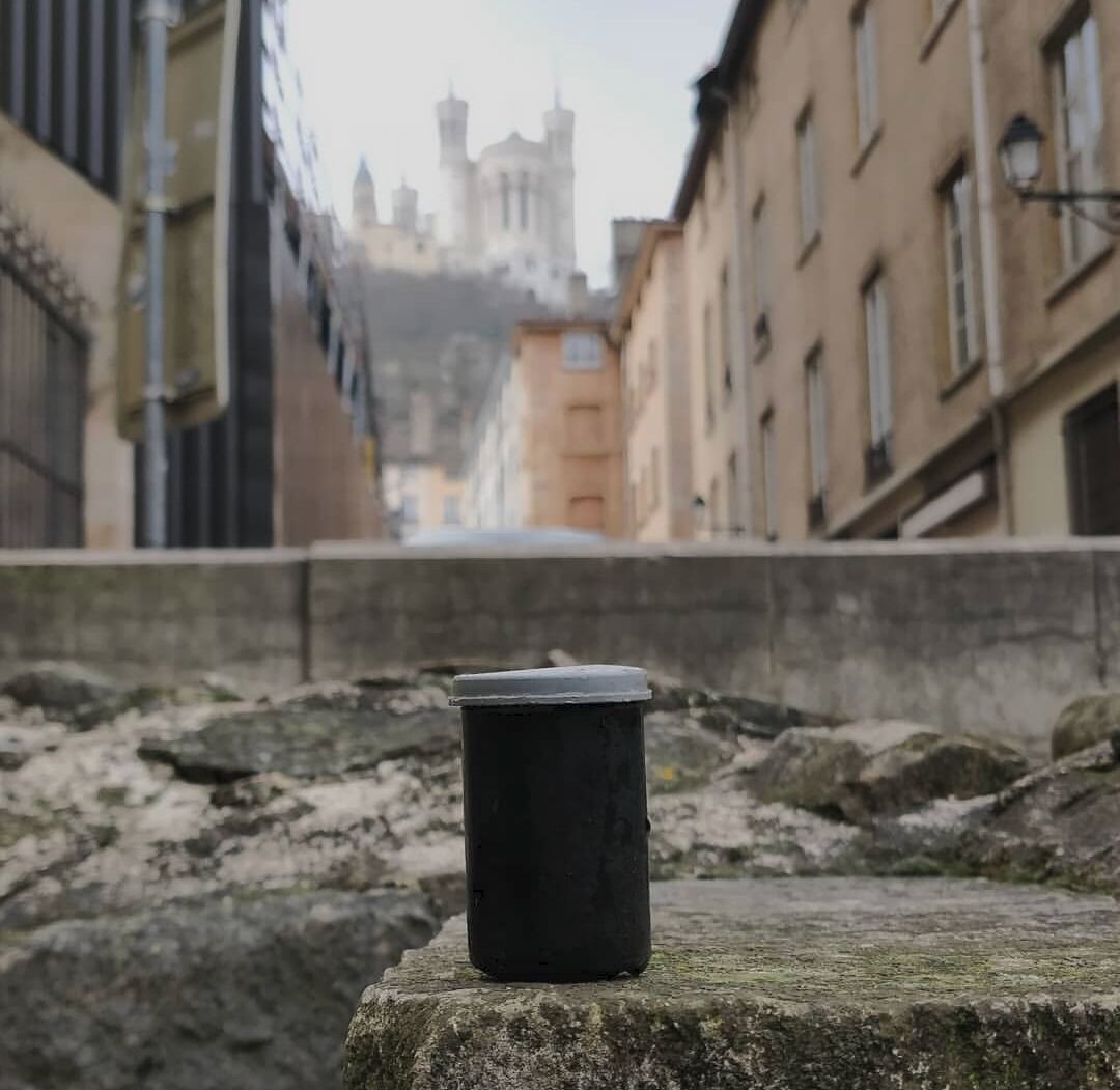 Cache urbaine posée sur un muret avec la basilique de Fourvière en arrière-plan